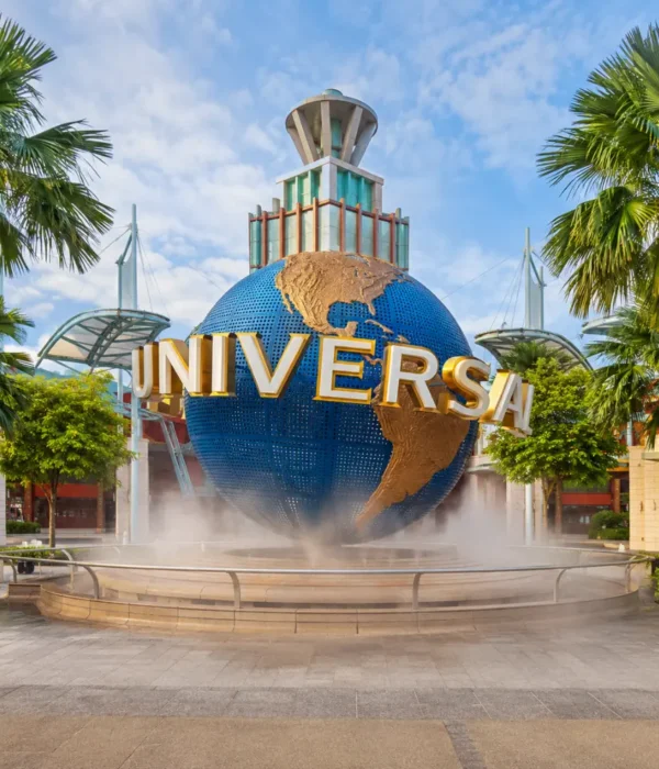 Universal Studios Singapore entrance with iconic globe, tropical palms, and bright morning travel atmosphere.