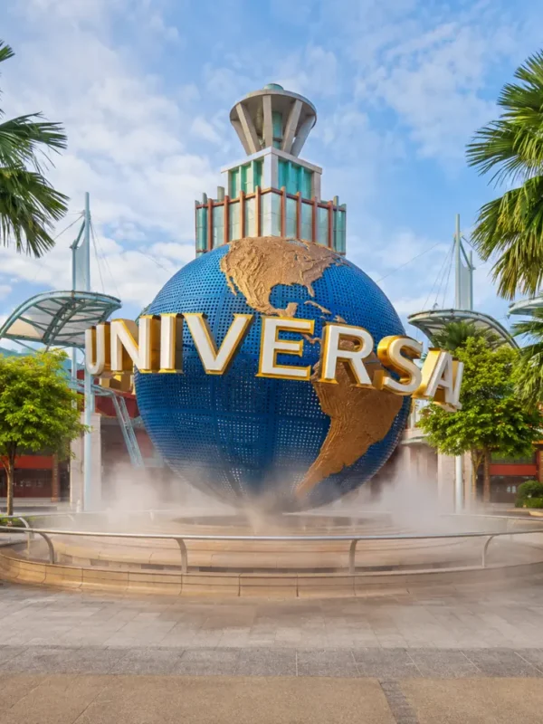 Universal Studios Singapore entrance with iconic globe, tropical palms, and bright morning travel atmosphere.