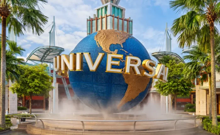Universal Studios Singapore entrance with iconic globe, tropical palms, and bright morning travel atmosphere.