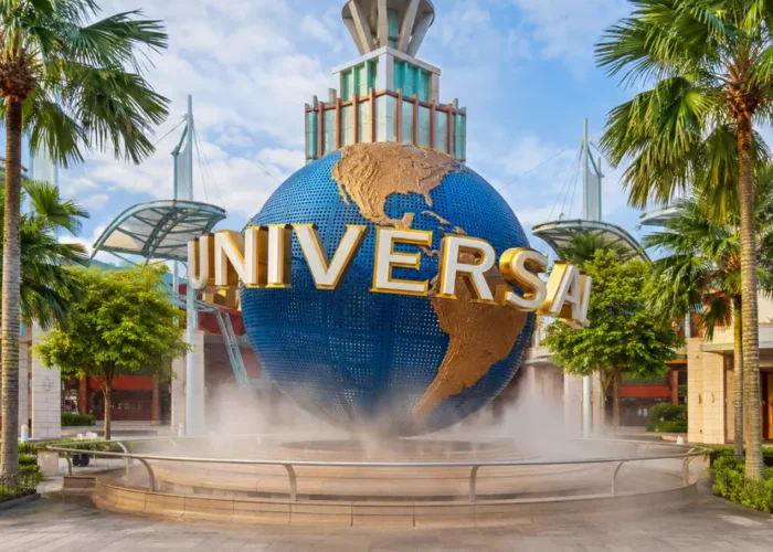 Universal Studios Singapore entrance with iconic globe, tropical palms, and bright morning travel atmosphere.