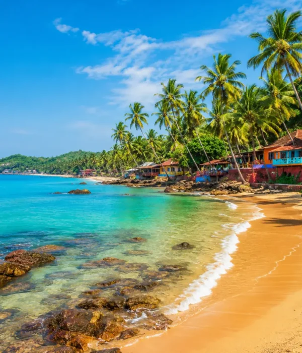 Goa beach with golden sand, blue sea, coconut palms and clear morning daylight for a tropical holiday escape.