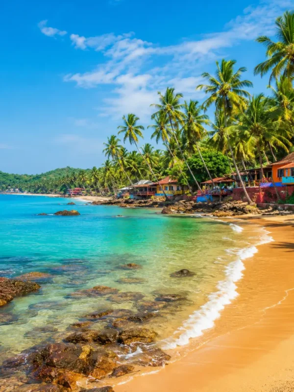Goa beach with golden sand, blue sea, coconut palms and clear morning daylight for a tropical holiday escape.