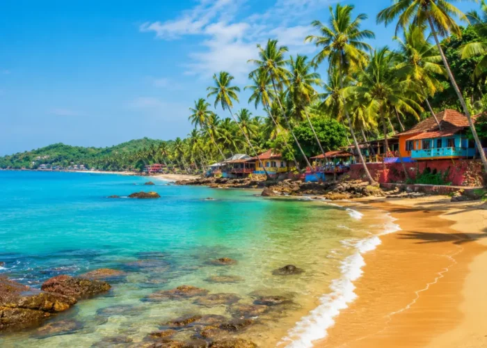 Goa beach with golden sand, blue sea, coconut palms and clear morning daylight for a tropical holiday escape.