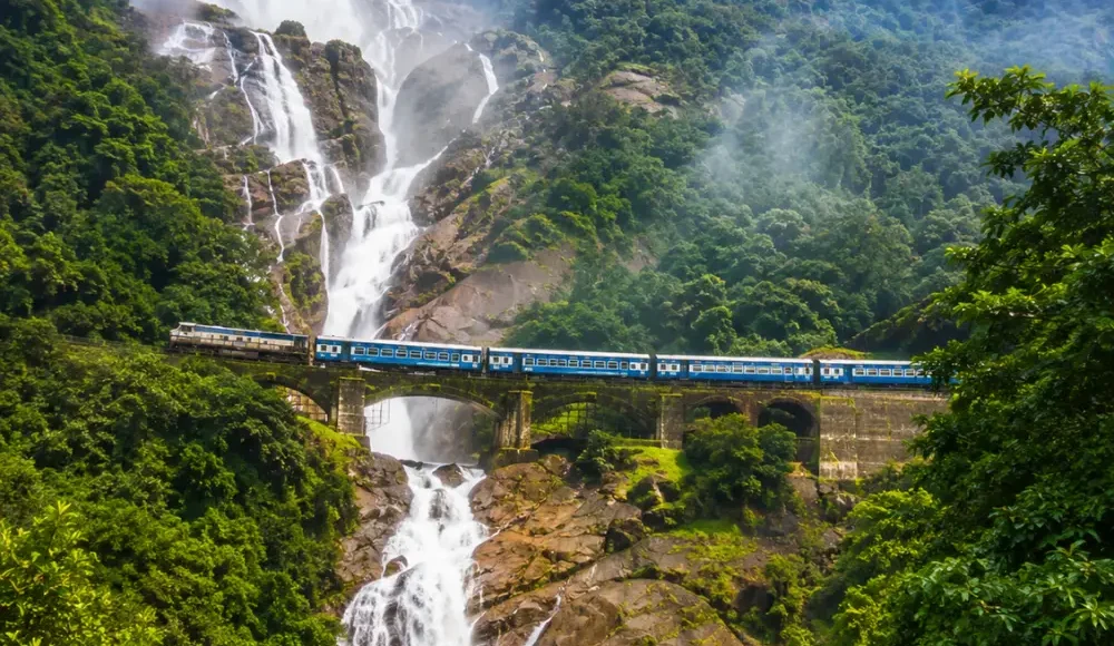 Dudhsagar Falls in Goa with powerful white cascades, lush Western Ghats forest and clear morning daylight.
