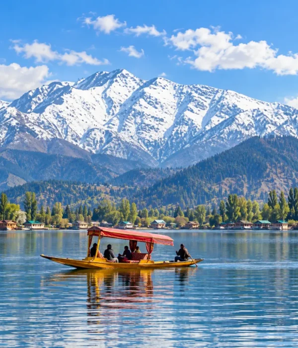 Shikara boat on Dal Lake in Srinagar, Kashmir, with snow-capped Himalayan mountains and scenic waterfront views